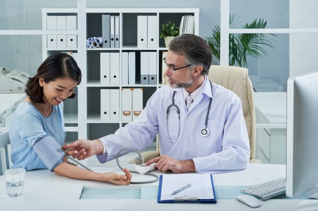Doctor-checking-blood-pressure-female-patient_1098-19334